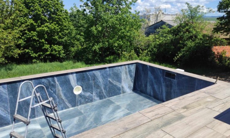 Terrasse dalle sur plot effet bois / Plage de piscine en gazon synthétique / Piscine carrelée en 60x120 poli brillant onyx bleu à Roanne