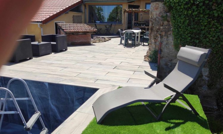 Terrasse dalle sur plot effet bois / Plage de piscine en gazon synthétique / Piscine carrelée en 60x120 poli brillant onyx bleu à Roanne