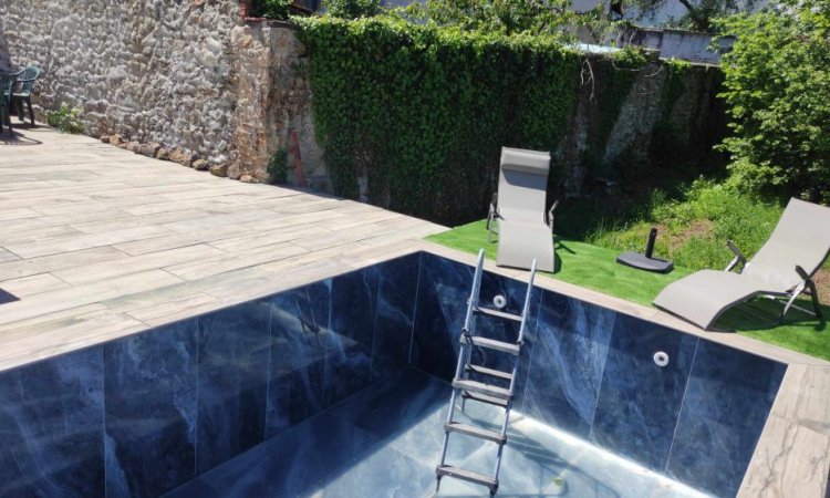 Terrasse dalle sur plot effet bois / Plage de piscine en gazon synthétique / Piscine carrelée en 60x120 poli brillant onyx bleu à Roanne